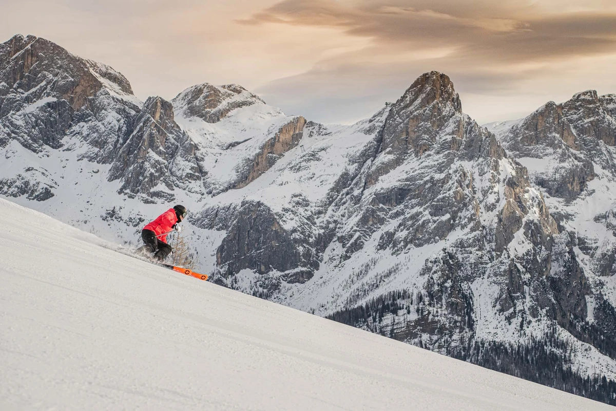 a solo skier skis in low-light in a moody and epic picture