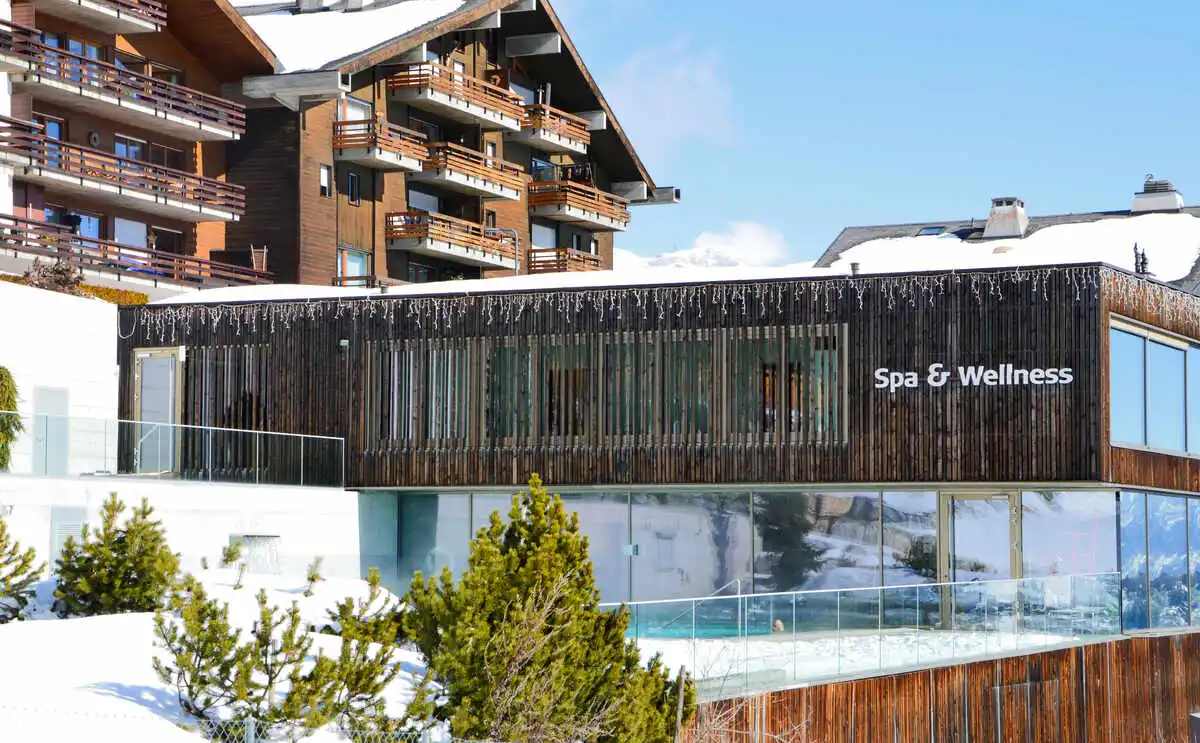 a modern building housing a spa and wellness centre in a ski resort sits surrounded by snow